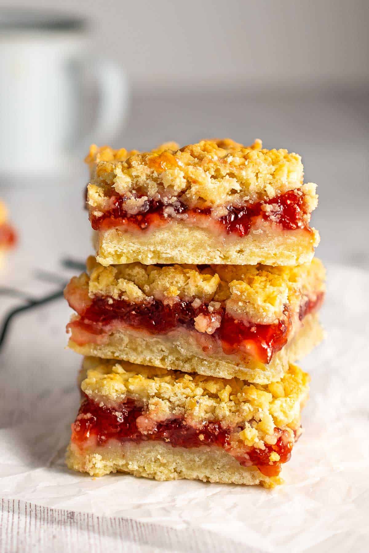 A stack of strawberry jam squares on a white background.