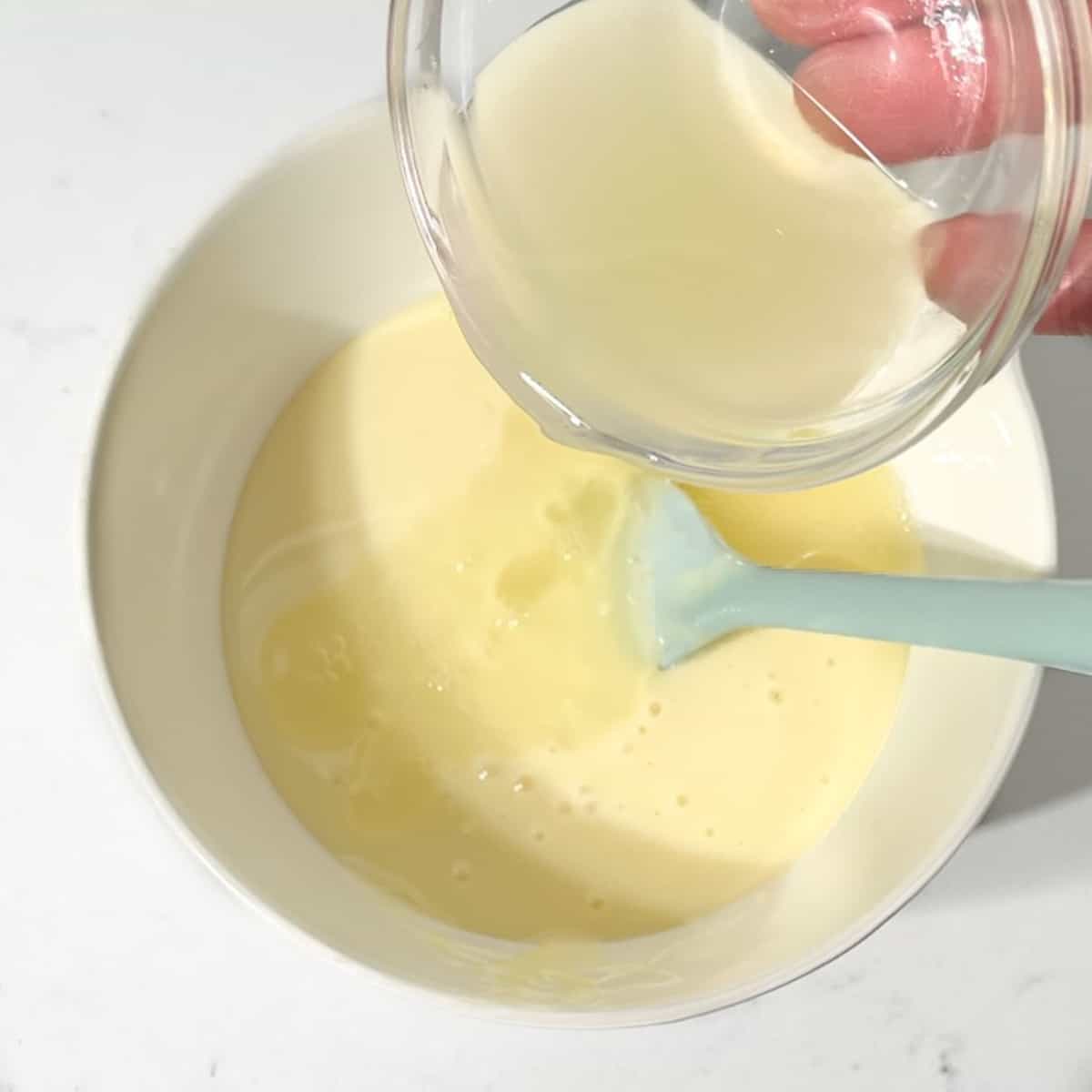 Adding lemon juice to the condensed milk.