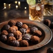 Rum and ginger truffles on a metal plate with a dark and stormy cocktail in the background