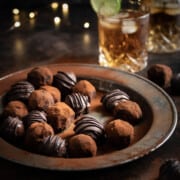 Rum and ginger truffles on a metal plate with a dark and stormy cocktail in the background