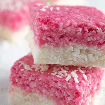 Two pieces of white and pink coconut ice stacked on top of each other.