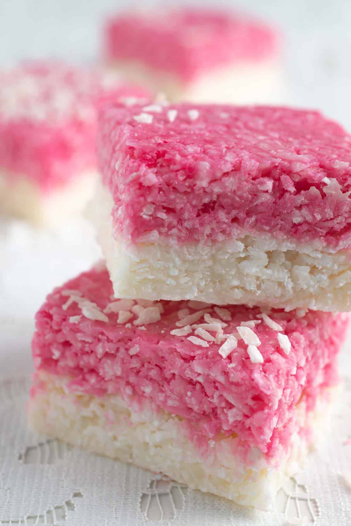 Two pieces of white and pink coconut ice stacked on top of each other.