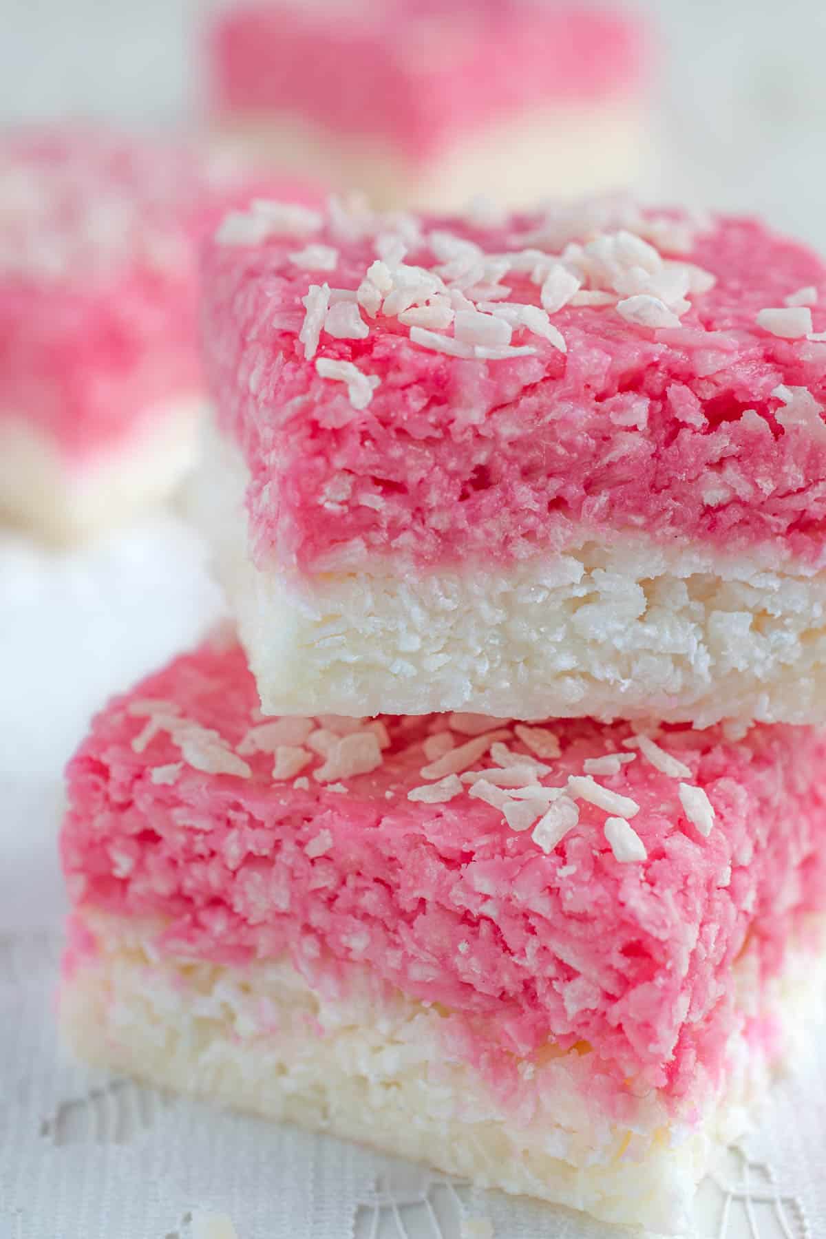 A few squares of coconut ice on a lace tablecloth.