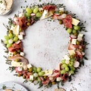 Christmas charcuterie board in a wreath shape with various meats, cheese and fruit.