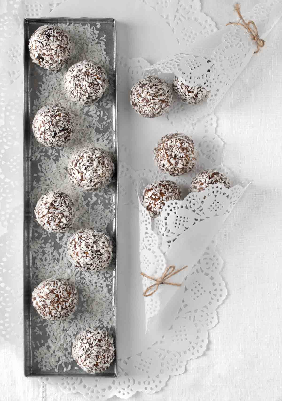 Date balls on a silver tray and white tablecloth.