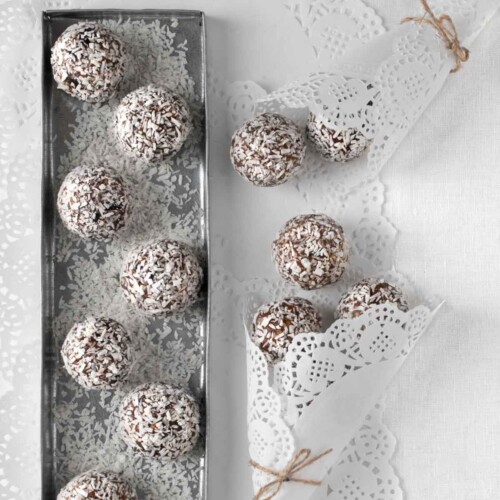 Date balls on a silver tray and white tablecloth.