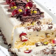 Cassata ice cream loaf showing a slice of ice cream with cherries, pistachios and chocolate shavings.