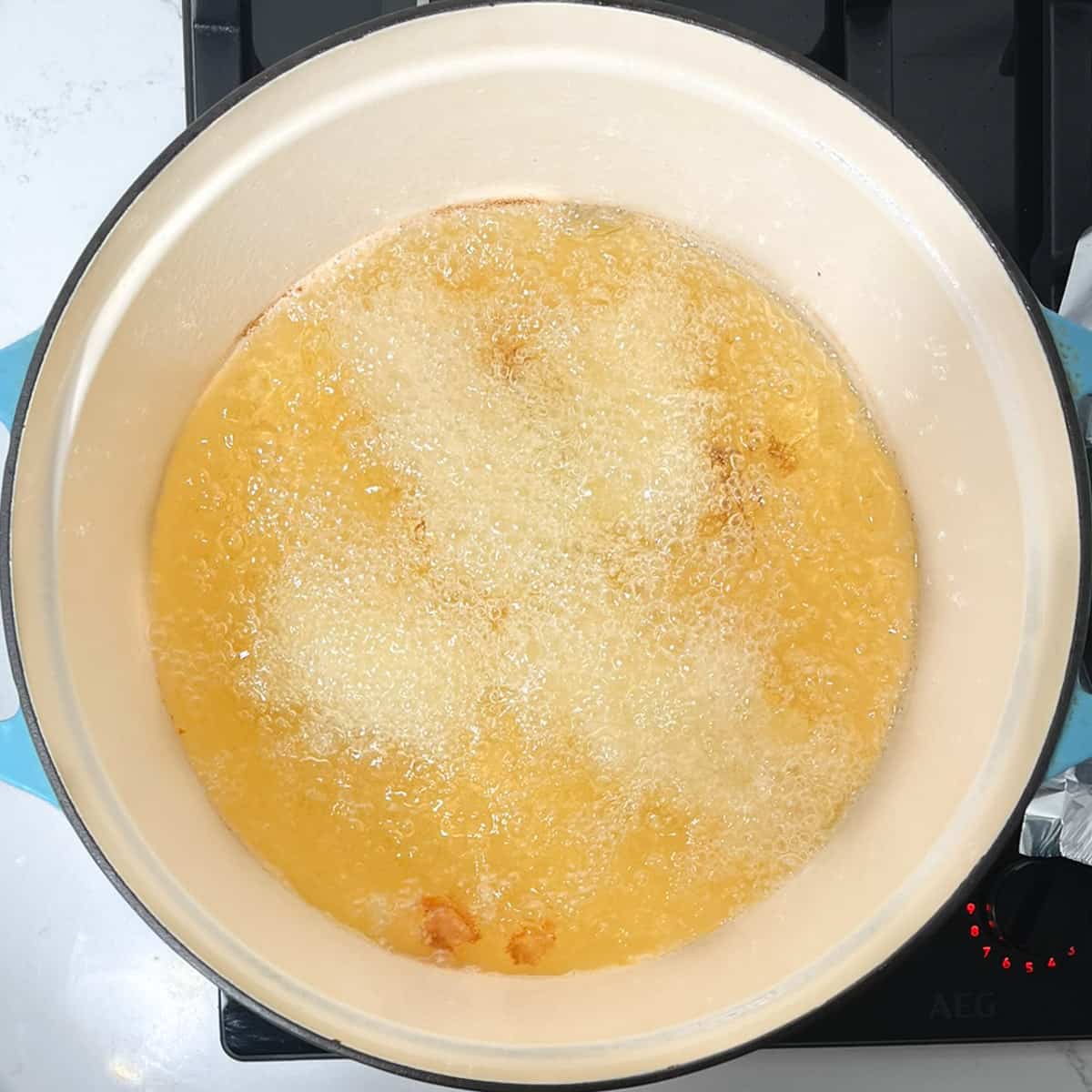 Frying the fish goujons in oil in a large pot.