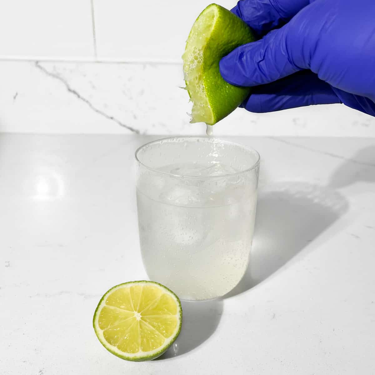 Squeezing lime into a glass.