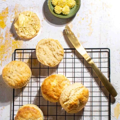 3-Ingredient scones on a black wire rack, served with some butter.