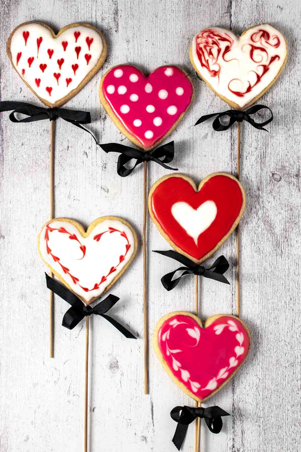 Six valentine's biscuits on sticks.