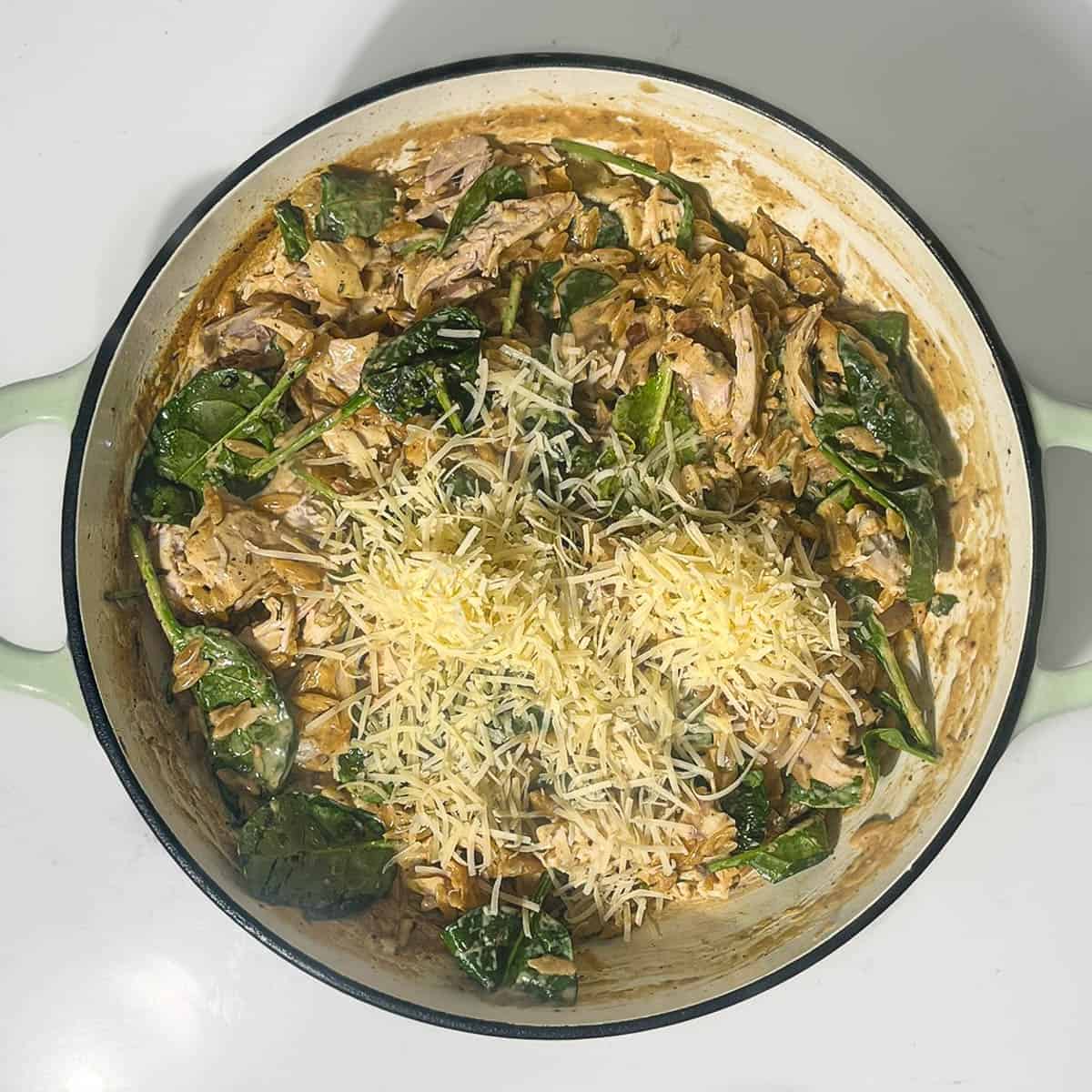 Adding parmesan and lemon juice to the orzo pasta.