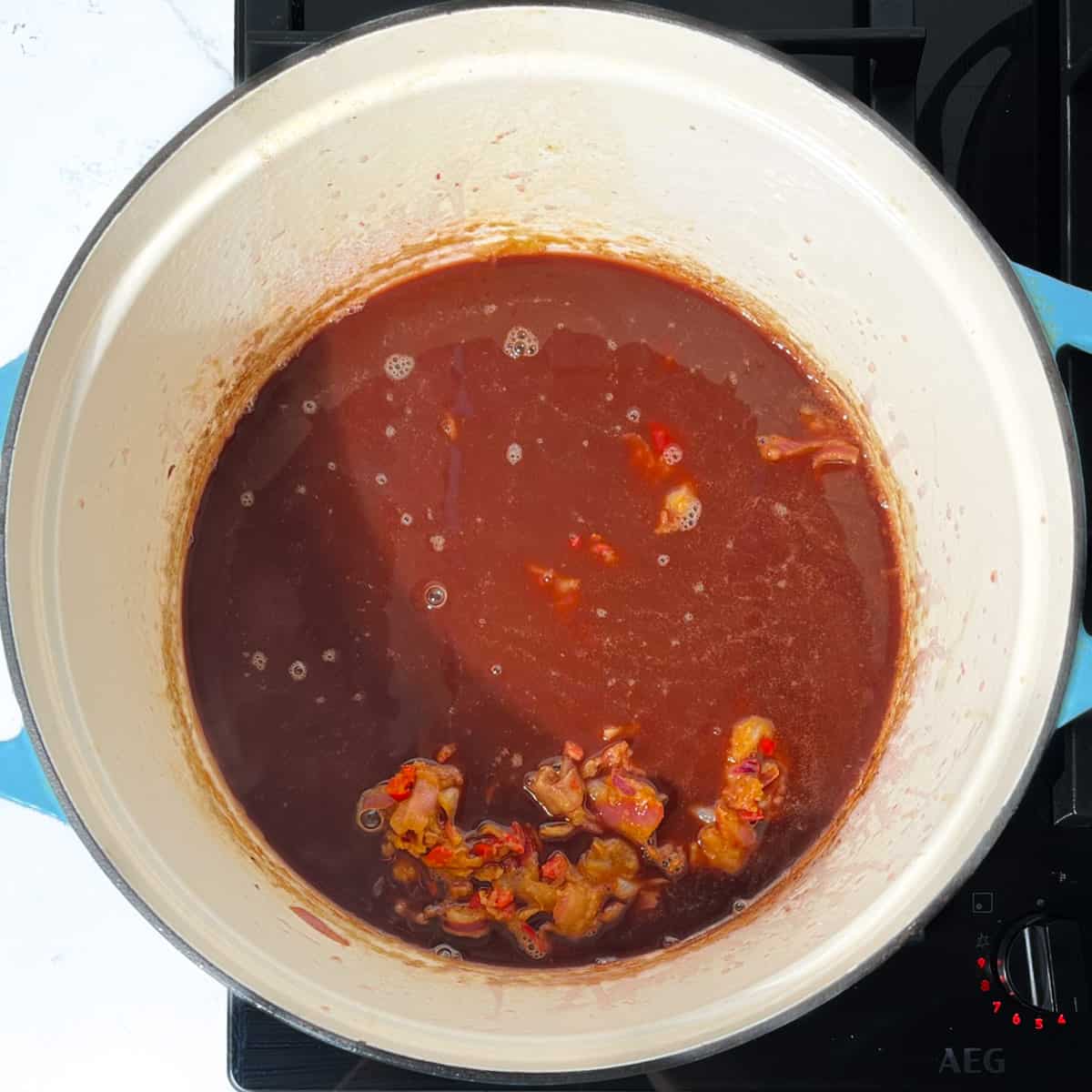 Adding the Trinchado sauce to the saucepan.