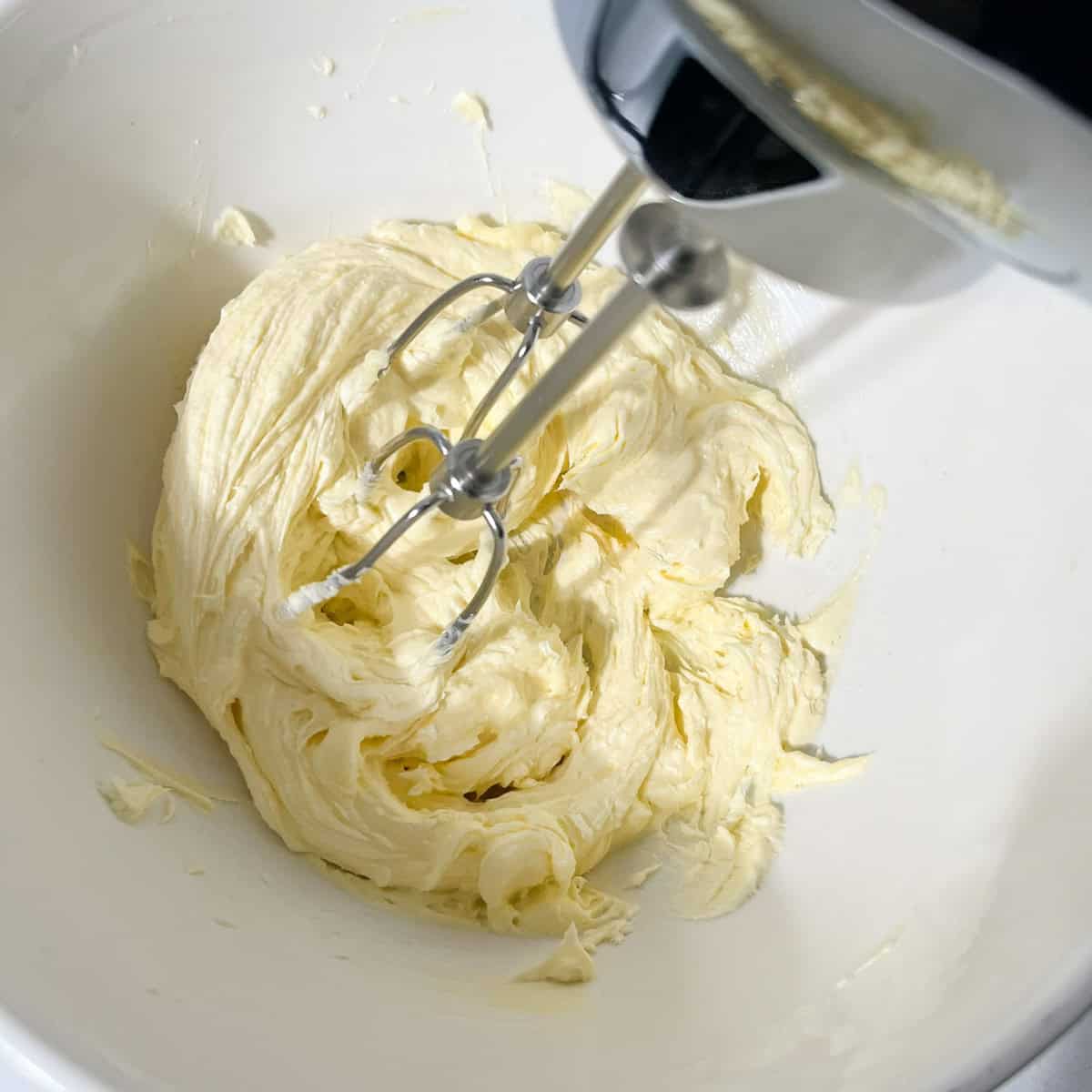 Butter and caster sugar beaten until smooth, creamy and slightly paler in a white mixing bowl.