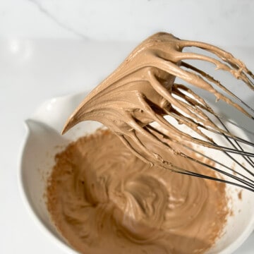 Showing the soft peak consistency of the coffee mousse on a whisk.