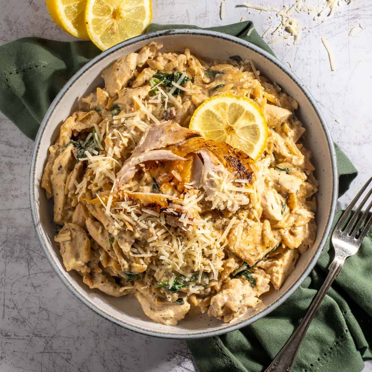 Lemon chicken orzo pasta with some sliced lemon.