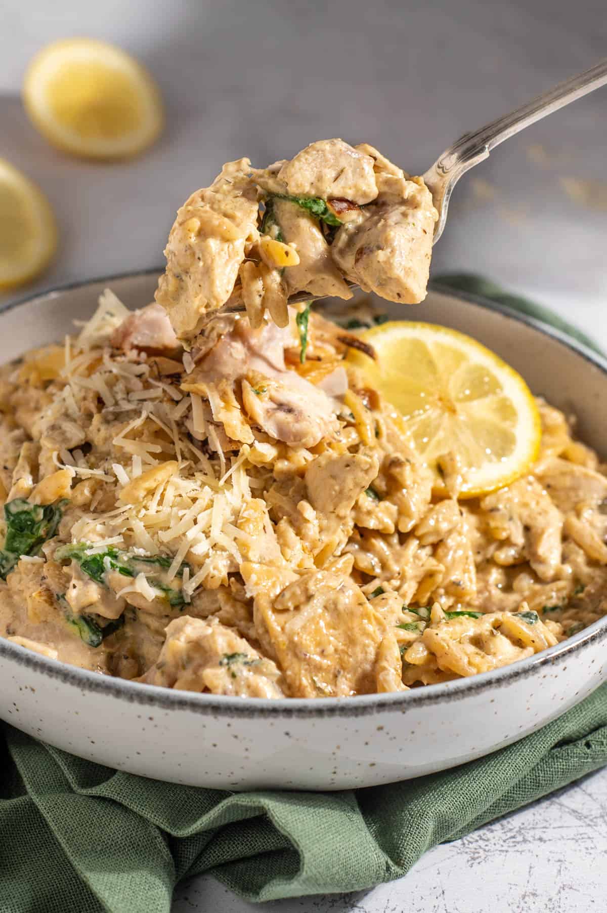 Lemon chicken orzo pasta with a spoonful on a fork.