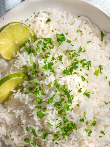 Coconut basmati rice with slices of lime and chopped coriander.