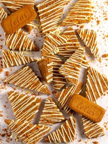 Biscoff cake slices cut into triangles and drizzled with white chocolate on a white background.