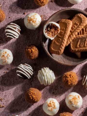 Biscoff truffles decorated in various ways on a mauve background.