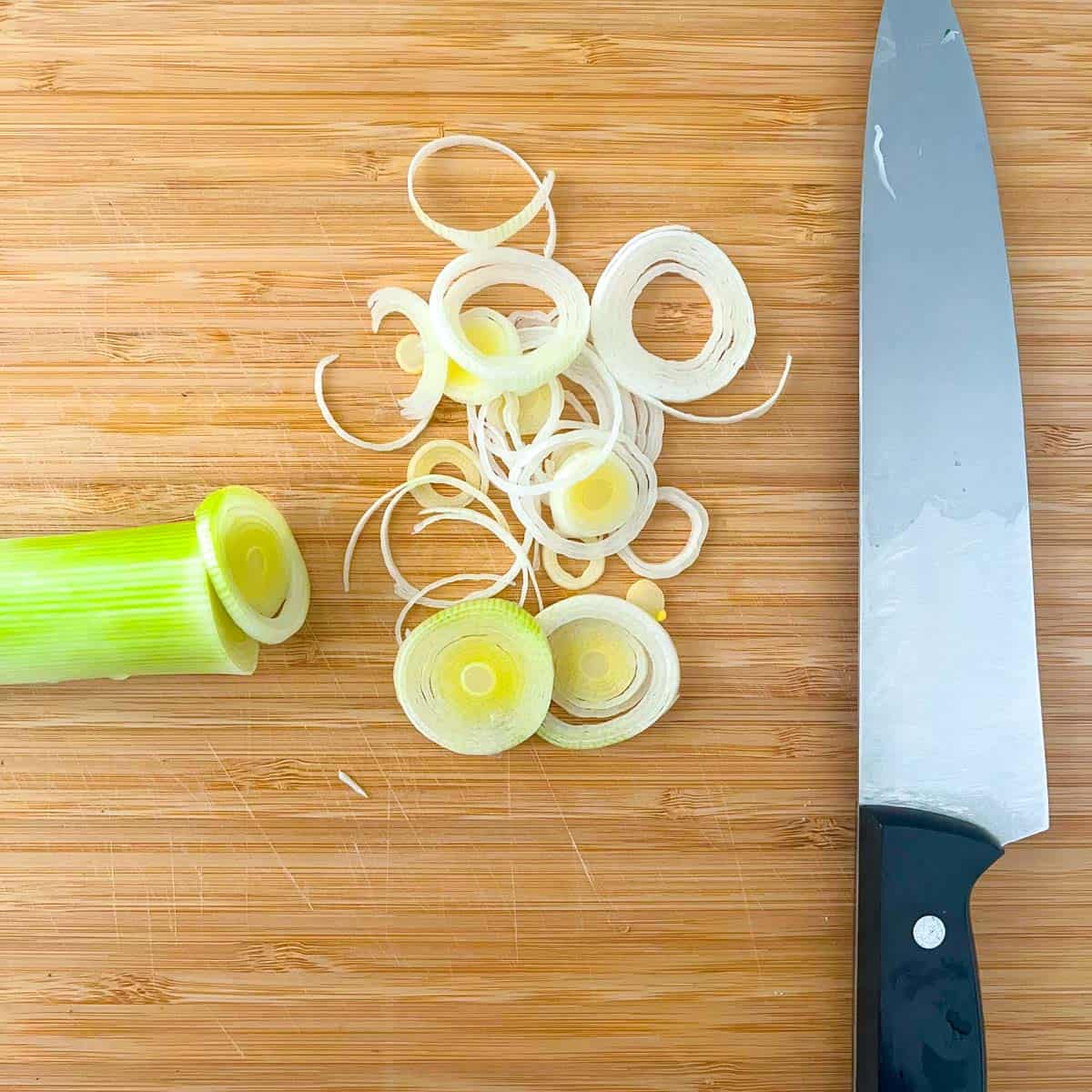 Chopping board with thinly sliced leeks.