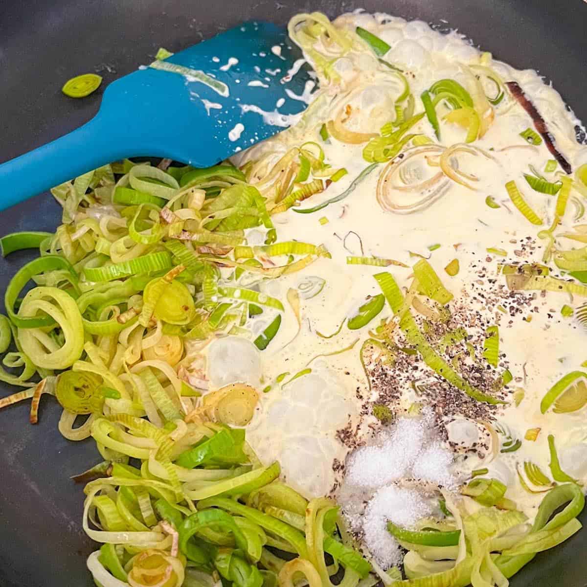 Add cream to fried leeks in a frying pan.