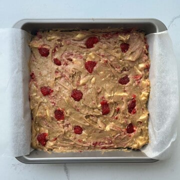 Raspberry and white chocolate blondies batter in a tin.