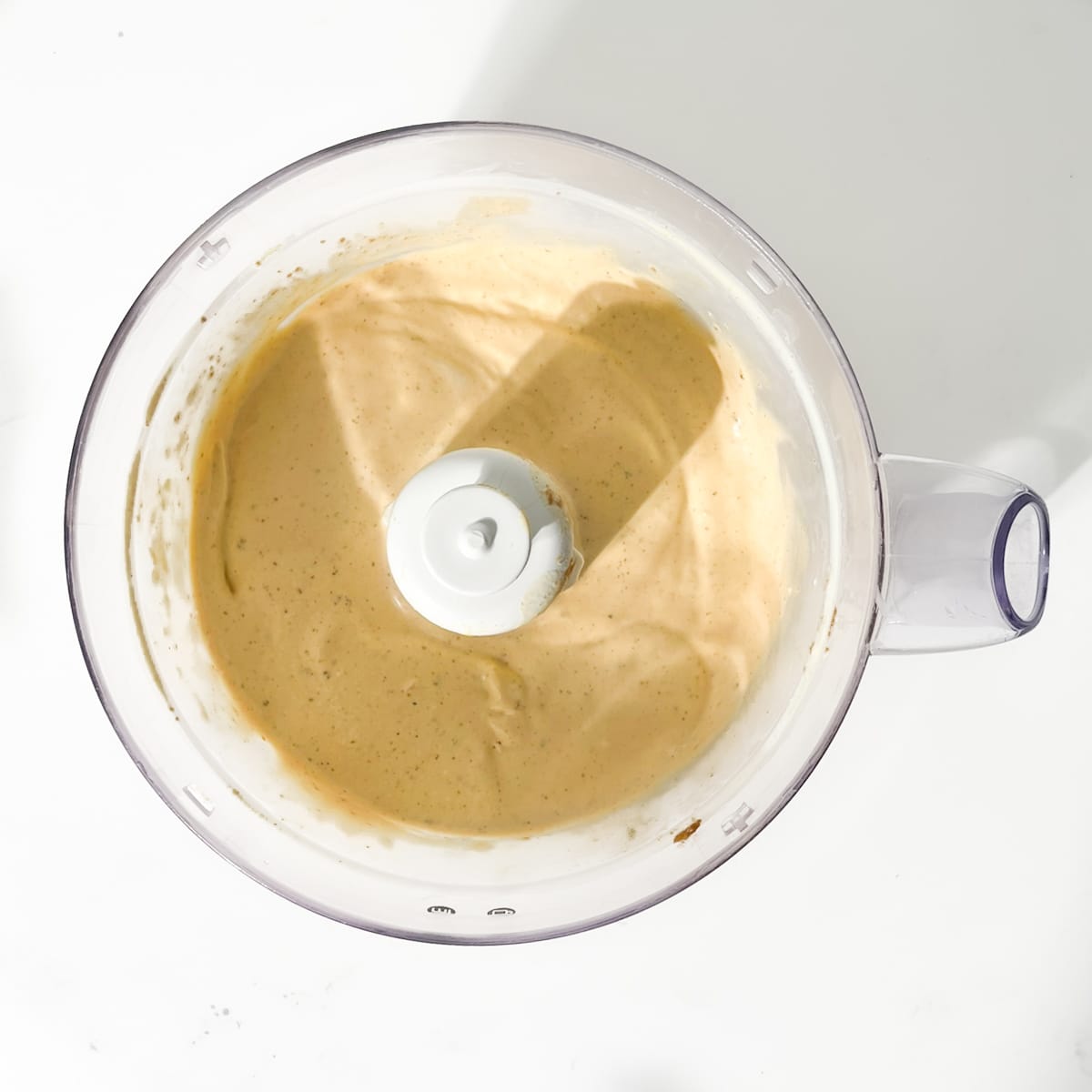 Blended milkshake in a food processor bowl.