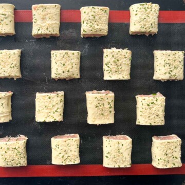 Chicken sausage rolls on a baking sheet ready for the oven.