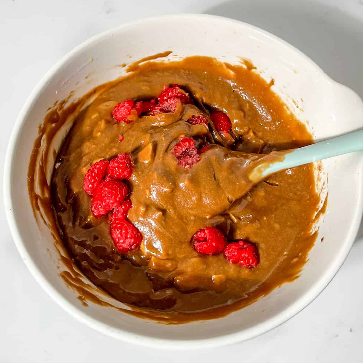 Folding raspberries into the blondie mixture.