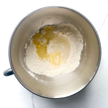 A mixing bowl with flour and added water and oil.