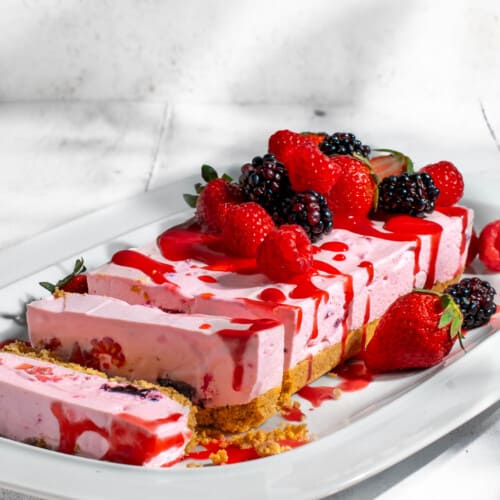 No bake berry cheesecake sliced on a white plate.