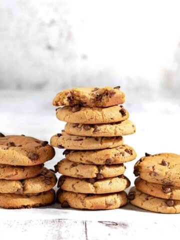 Condensed milk chocolate chip cookies stacked in three piles.