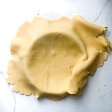 Draping the pastry into the tart case.
