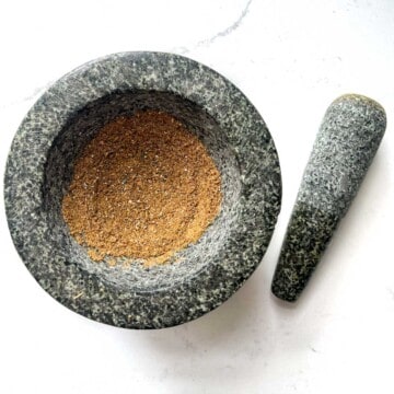 Ground down toasted fennel and cardamom seeds in a mortar and pestle.