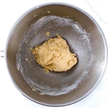 Pastry dough in the bowl of a stand mixer.