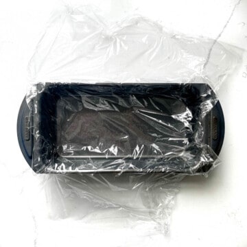A loaf tin lined with plastic wrap. 