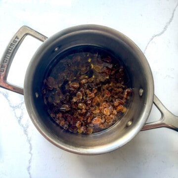 Sultanas added to a saucepan, covered with water.