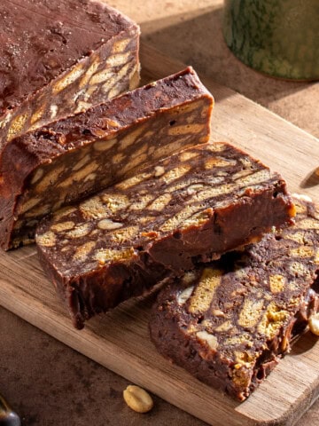 Sliced tinginys, a Lithuanian no-bake biscuit cake with cocoa, condensed milk, peanuts and chocolate chips.