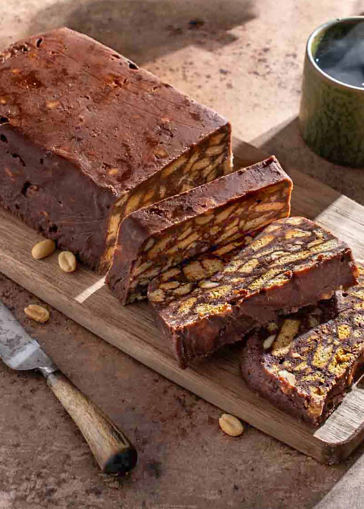 Sliced tinginys, a Lithuanian no-bake biscuit cake with cocoa, condensed milk, peanuts and chocolate chips.
