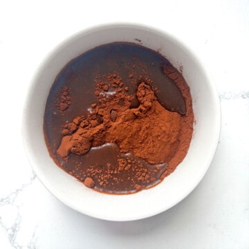Cocoa powder and coffee added to a small white bowl.