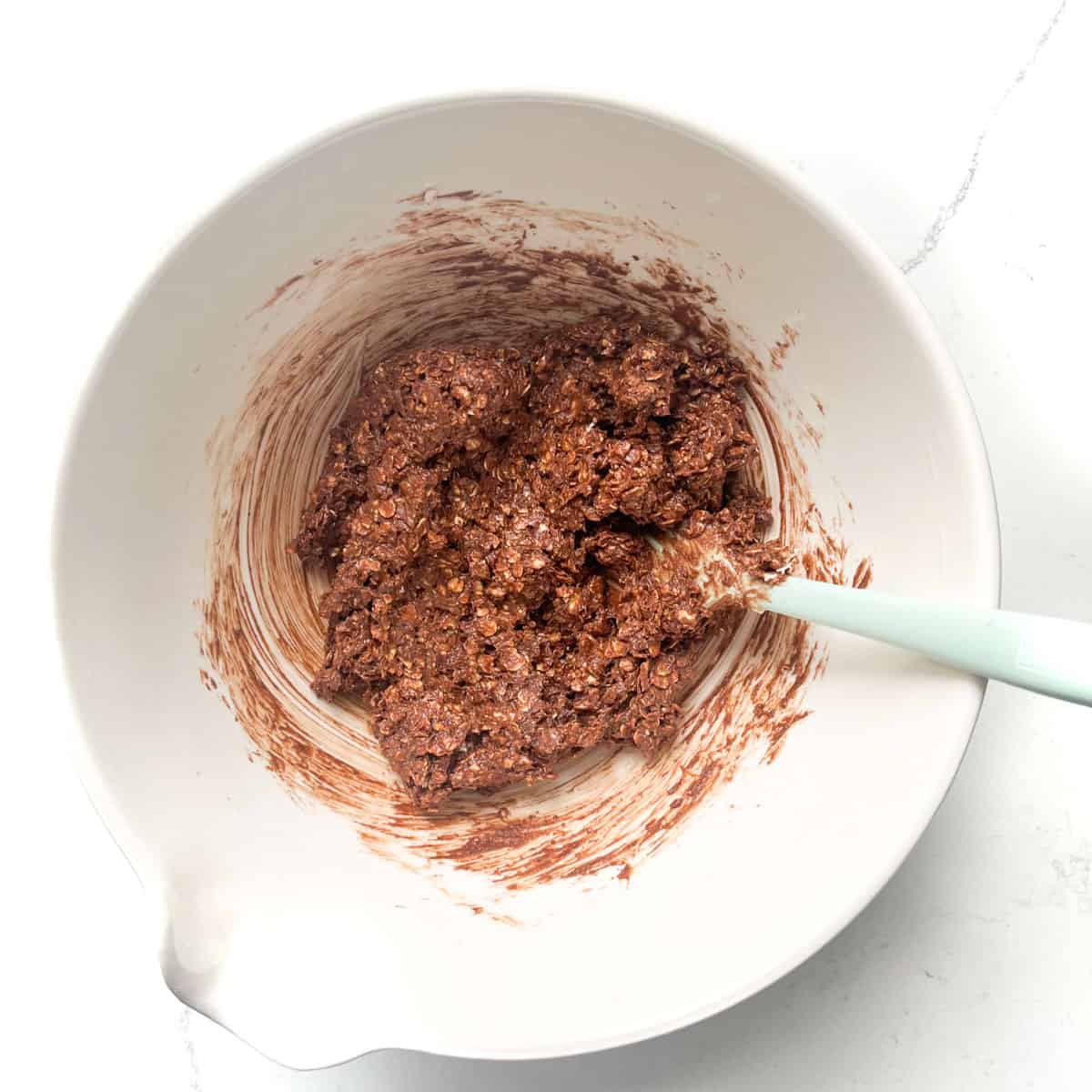 Chokladbollar mixture in a white bowl, ready for rolling.