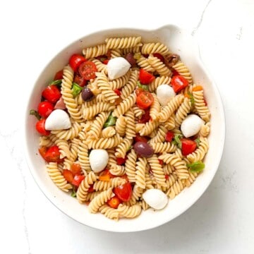 Completed pasta fredda salad in a large white bowl.