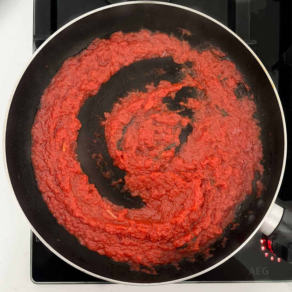 The cooked sauce for pasta alla sorrentina in a black frying pan.