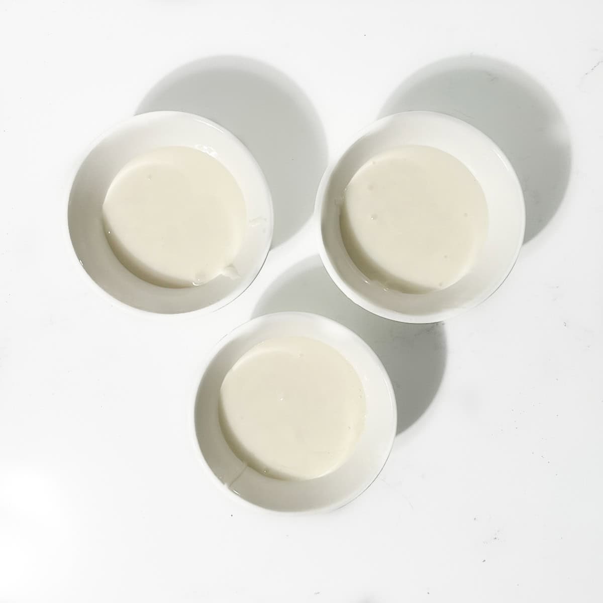 Three small bowls of white icing.