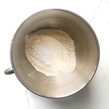 Adding flour and salt to a large mixing bowl.