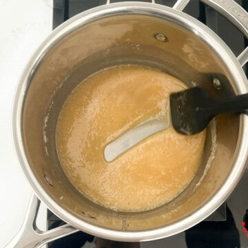 Testing the consistency of the pe-de-molesque caramel by drawing a line through it and leaving a clear trail on the bottom of the saucepan.