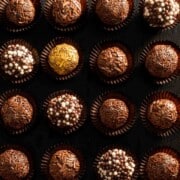 Brigadeiros in paper cases with various toppings.