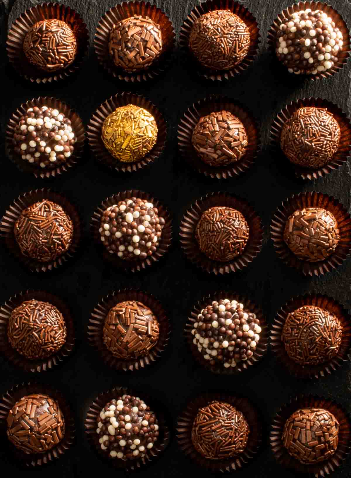 Brigadeiros in paper cases with various toppings. 