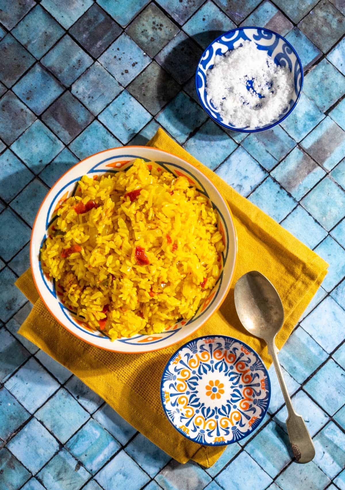 Arroz Amarillo in a bowl on top of a yellow napkin.